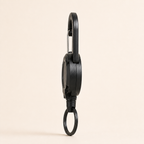 Side-profile studio view showing the depth of the TUGLO reel body and carabiner