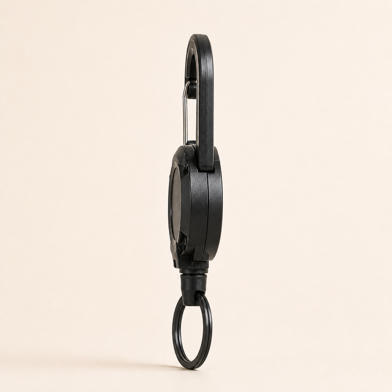 Side-profile studio view showing the depth of the TUGLO reel body and carabiner